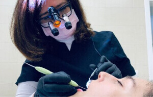 Dentista colocando una ortodoncia en aragón invisible (invisalign)